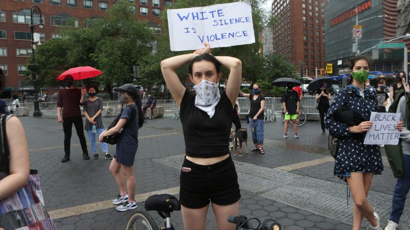 A woman holds a protest sign that says "white silence is violence" | Krista Kennell/ZUMA Press/Newscom