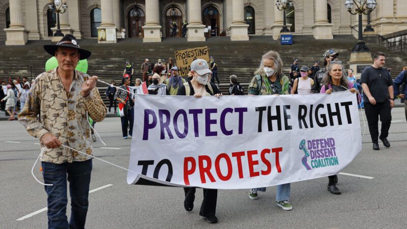 Demonstrators in Australia hold a banner that reads "Protect the right to protest." | Ye Myo Khant/ZUMAPRESS/Newscom
