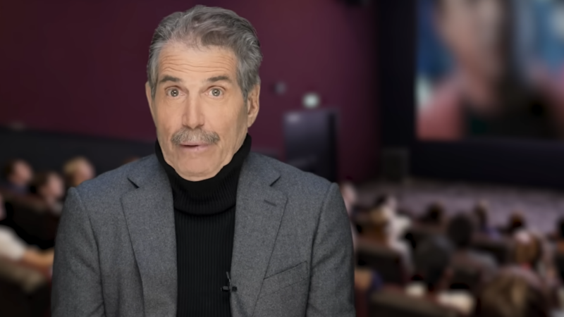 John Stossel stands in front of a movie theater | Stossel TV