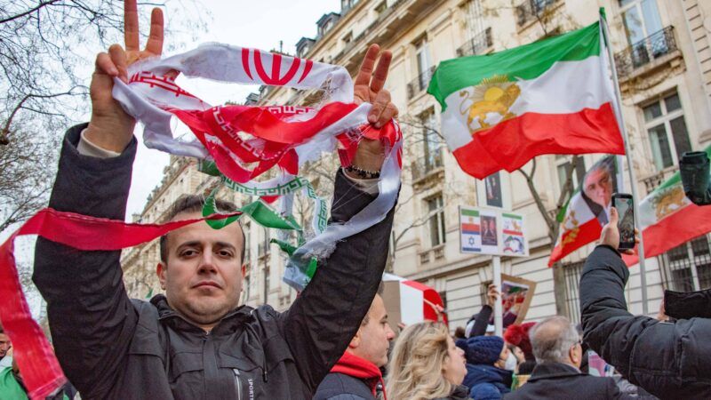 Protester holds tattered Iranian flag. | Erez Lichtfeld/SIPA/Newscom
