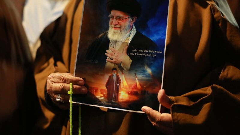 Iraqi Shiites shout slogans as they carry a portrait of Ayatollah Ali Khamenei and wave Iranian flags during a protest near the US embassy in Baghdad against recent US-Israeli strikes on Iran. Bagdad, Iraq. 28 February 2026. | Ameer Al-Mohammedawi/dpa/picture-alliance/Newscom