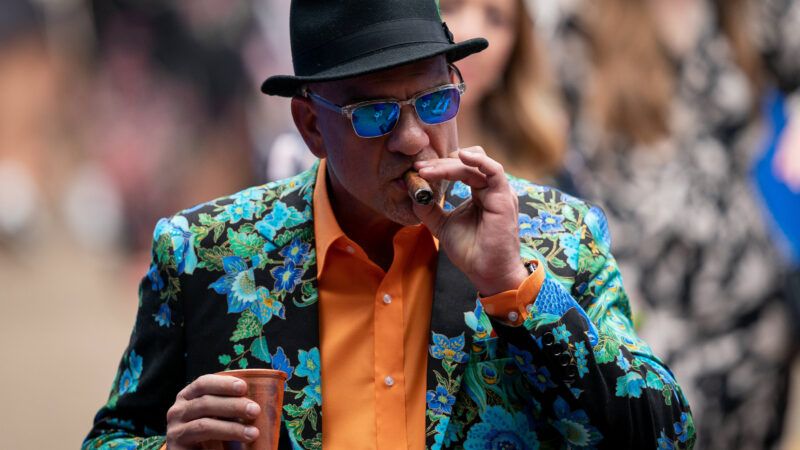 Tom Chiodo smokes a cigar on Derby Day at Churchill Downs in Louisville, Kentucky | Bryan Woolston/ZUMA Press/Newscom