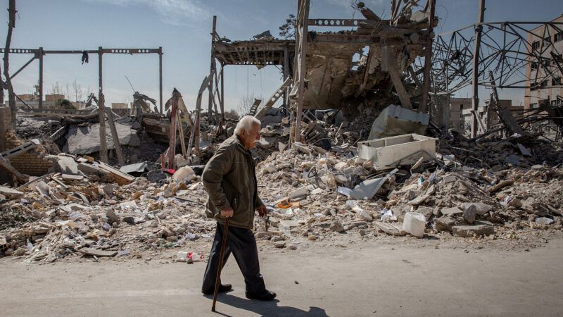 Older Iranian man with a bombed out building behind him | Credit: Arash Khamooshi/Polaris/Newscom