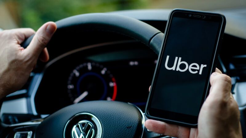 A driver holds a phone with the Uber app | Oleksandr Lutsenko/Dreamstime