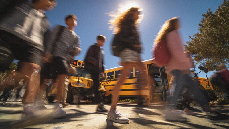 A blurry picture of students in a crosswalk. | Midjourney