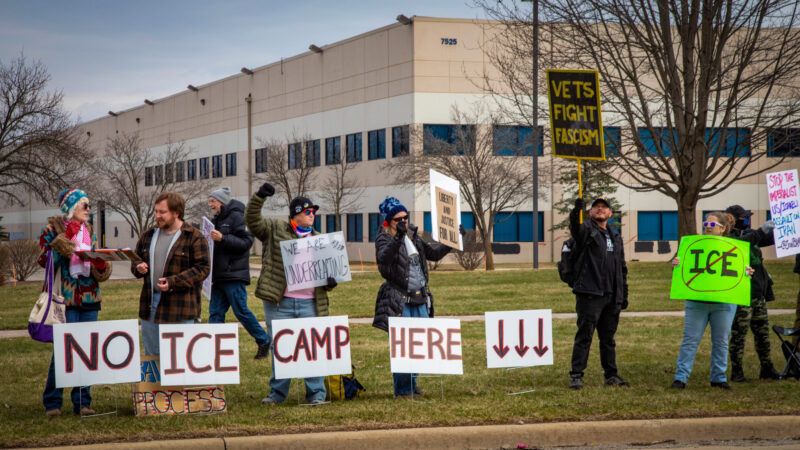Protesters hold signs along the side of the road, including one that says "No ICE Camp Here." | Jim West/UCG/Universal Images Group/Newscom