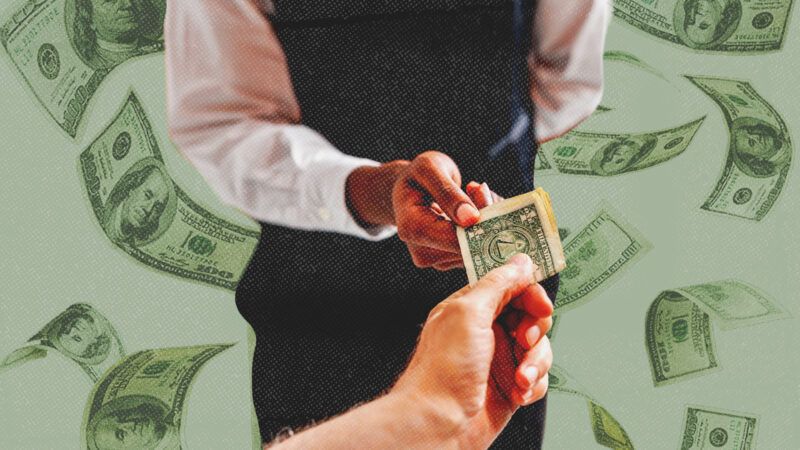 A man hands a waiter a tip | Dragoscondrea/Mikael Damkier/Dreamstime