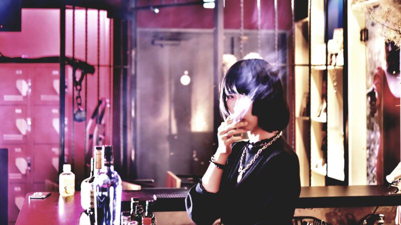 A woman smoking a cigarette inside a bar | Photo: EyeEm Mobile GmbH/iStock