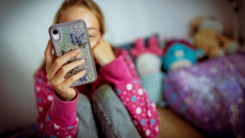 Photo of a teenager looking at a smart phone | Kira Hofmann/picture alliance / photothek.de/Newscom