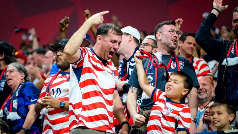 Fans of all ages and various races celebrate in the stands, wearing U.S. Soccer jerseys with wavy red stripes. | Photo: Billy Schuerman/Cal Sport Media/Newscom