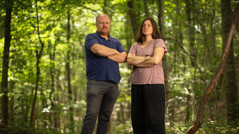 Two people standing in a wooded area | Photo: Institute for Justice