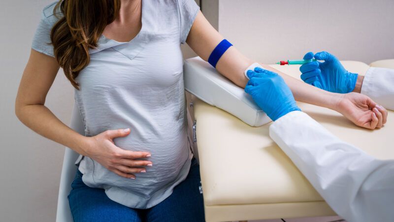 A doctor preps a pregnant person's arm for a blood draw | Photo: AndreyPopov/Newscom
