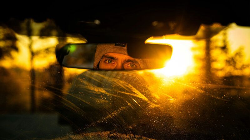 A photo of a man's eyes seen through a rear-view mirror | Photo: Kovina Duric/Unsplash