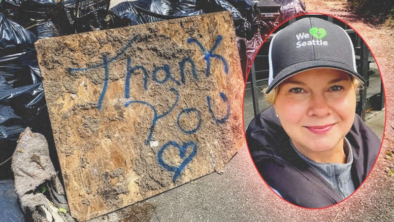 A piece of wood with "Thank you" written on it is propped against piles of trash. A picture of a blonde woman with a "We Heart Seattle" hat is next to it. | Courtesy of We Heart Seattle