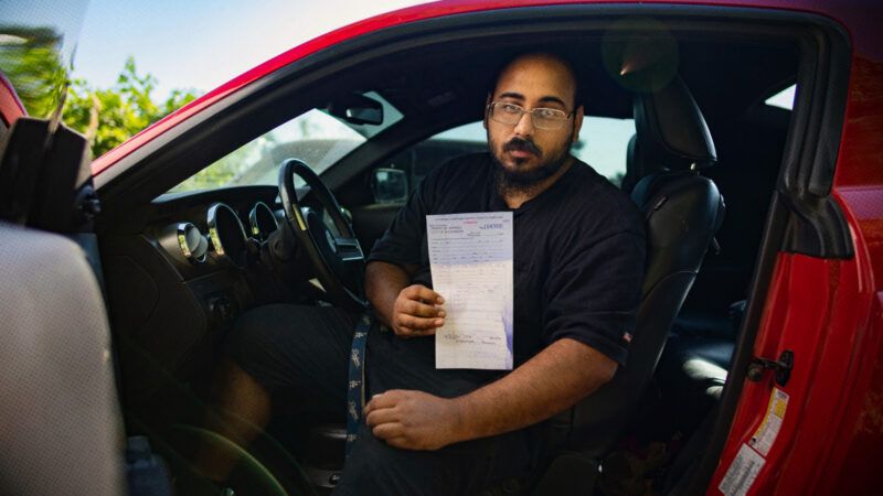 Mario Rosales sits in his car while holding up a copy of the citation he received in June 2022 | Institute for Justice