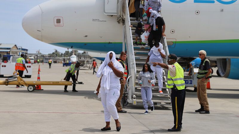 People deboarding a plane | Photo: Haitians deported from the U.S. deplane in Haiti; Ketlain Difficile/A.P.