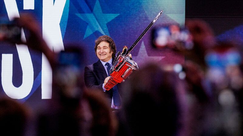 Javier Milei wielding a chainsaw in front of a crowd | Jason C. Andrew/Bloomberg via Getty