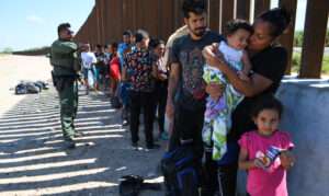 Migrantes esperan ser procesados ​​en la frontera entre Estados Unidos y México en Eagle Pass, Texas.