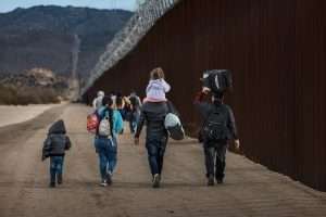 A group of asylum seekers walk along the U.S.-Mexico border near San Diego, California