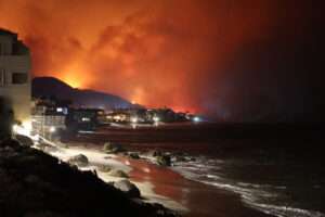 Beach homes in the Pacific Palisades area of Los Angeles, as wildfires rage just over the horizon.