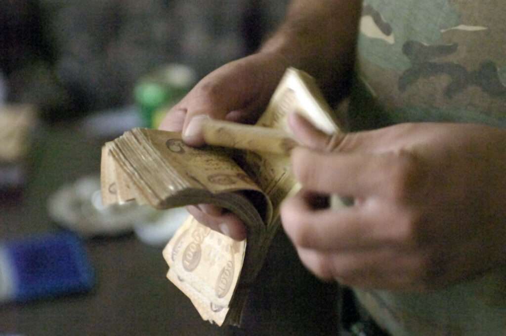 A Sons of Iraq member counts his cash after officials from 1st Brigade, 1st National Police Division, paid him with government of Iraq funds in the Karadah District of eastern Baghdad on Nov. 12.