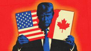 President Donald Trump rips a paper in half, with the U.S. flag on one side and the Canadian flag on the other.