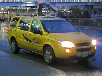 A cab with its light off at the airport.