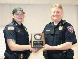 Officer Lindsey Green (left) receives an officer of the month award from Vian Police Chief Ted Johnson