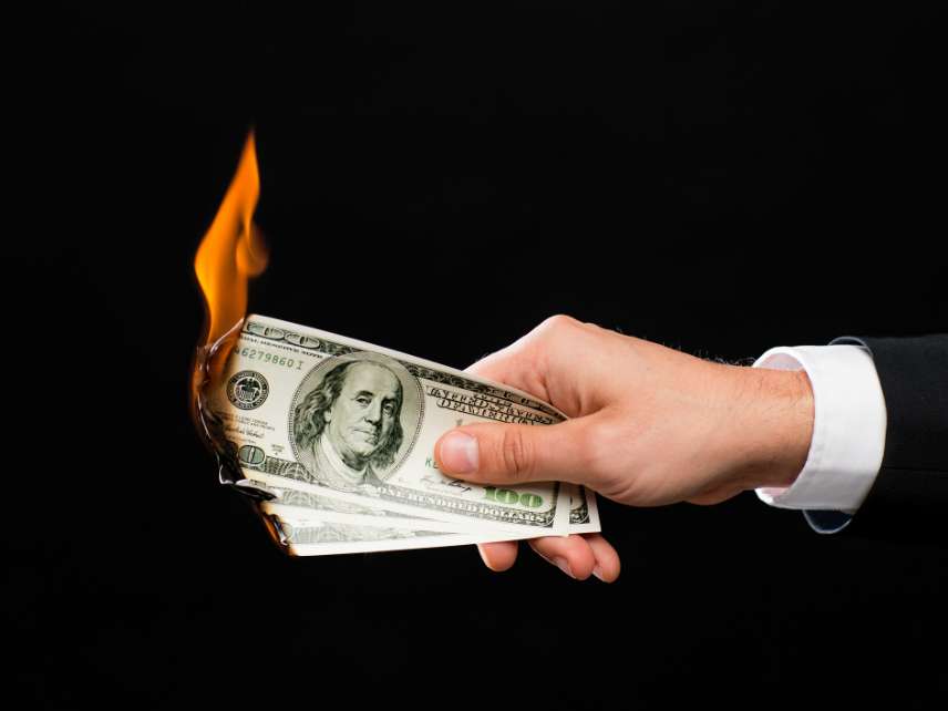 Close up of male hand holding burning dollar money