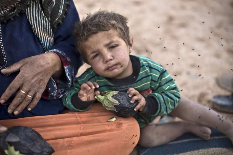 A Syrian refugee child at an informal tent settlement near the Syrian border in Jordan in June. (Muhammed Muheisen/Associated Press)