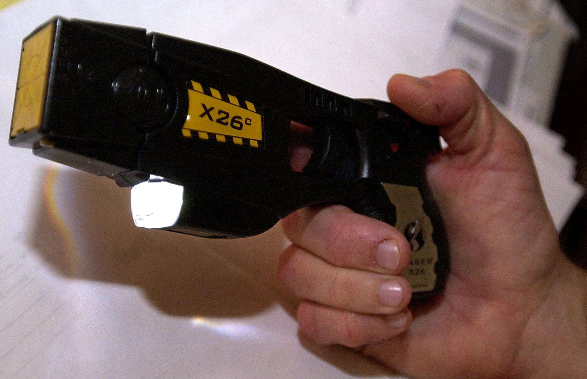 Steve Tuttle, director of communications for Taser International, Inc., holds the X26c stun gun Wednesday, Nov. 24, 2004 at the company's headquarters in Scottsdale, Ariz. (AP Photo/Tom Hood)