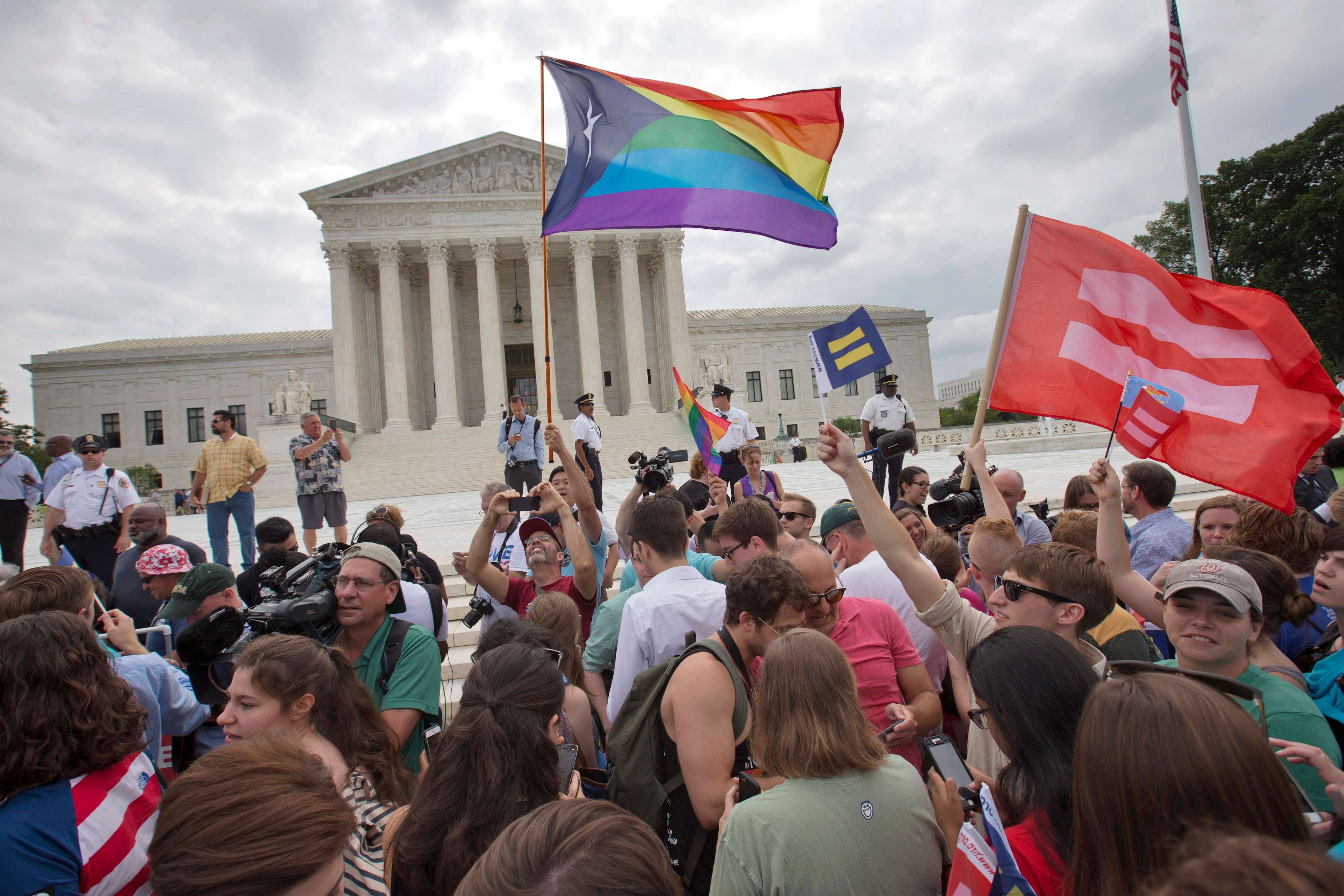 The crowd reacts as the ruling on same-sex marriage was announced outside of the Supreme Court in Washington, Friday June 26, 2015. The Supreme Court declared Friday that same-sex couples have a right to marry anywhere in the US. (AP Photo/Jacquelyn Martin)