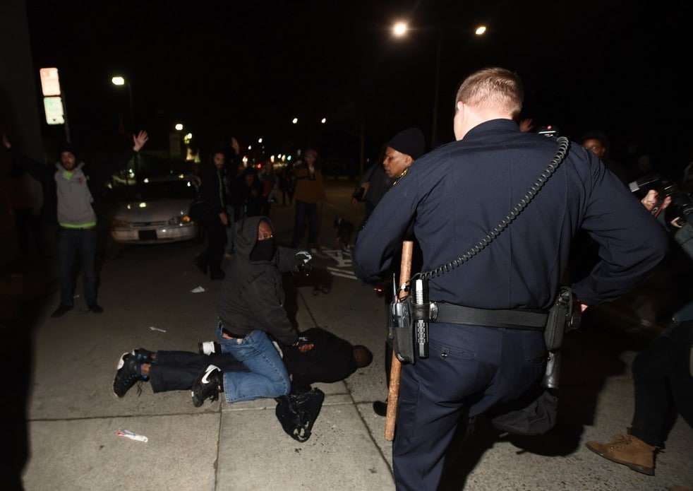 An Oakland Police Department officer (R) approaches as plainclothes California Highway Patrol detectives makes an arrest in Oakland, California December 10, 2014. Chief Avery Browne, commander of the California Highway Patrol's Golden Gate Division, said two plainclothes CHP detectives were surrounded by up to 50 demonstrators who ignored orders to back off, despite one of the officers first taking out his baton and identifying himself as police. Picture taken December 10, 2014. REUTERS/Noah Berger (UNITED STATES - Tags: CIVIL UNREST CRIME LAW) ATTENTION EDITORS: PICTURE 10 OF 10 PICTURES FOR A PICTURE AND ITS STORY PACKAGE 'DETECTIVE'S GUN DRAWN IN OAKLAND' SEARCH 'OAKLAND GUN' FOR ALL IMAGES