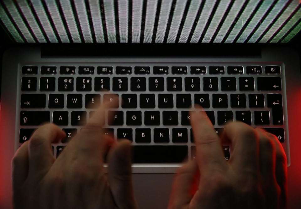 A stream of binary coding, text or computer processor instructions, is seen displayed on a laptop computer screen as a man works to enter data on the computer keyboard in this arranged photograph in London, U.K., on Wednesday, Dec. 23, 2015. The U.K.s biggest banks fear cyber attacks more than regulation, faltering economic growth and other potential risks, and are concerned that a hack could be so catastrophic that it could lead to a state rescue, according to a survey. Photographer: Chris Ratcliffe/Bloomberg