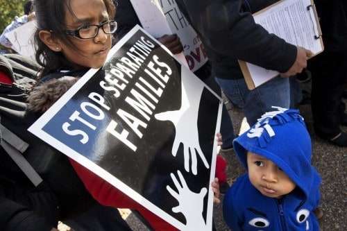 US citizens Esmeralda Tepetate, 10, with her brother Sebastian, 2, whose parents are originally from Mexico, holds a sign that says "stop separating families" during a rally for comprehensive immigration reform, Friday, Nov. 7, 2014, outside of the White House in Washington. (Jacquelyn Martin/AP)